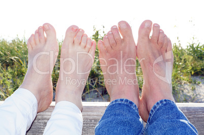 Couple at the Beach with feet in the summer sunlight
