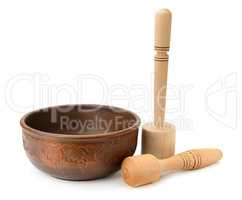 earthenware dish and wooden pestle isolated on white background