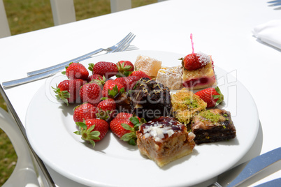 The plate with fresh strawberries and Turkish delights in hotel,