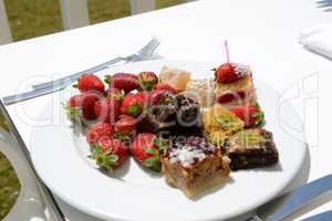 The plate with fresh strawberries and Turkish delights in hotel,