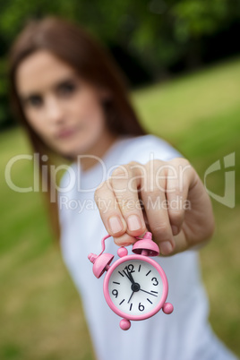 Young Woman Holding a Pink Alarm Clock