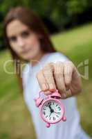 Young Woman Holding a Pink Alarm Clock