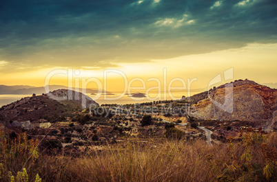 Colorful sunset view of mountains and sea and dramatic clouds on