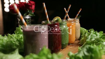 Various freshly blended smoothies on wooden tray
