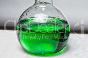 Green liquid in glass flask