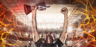 Composite image of happy rugby player holding trophy