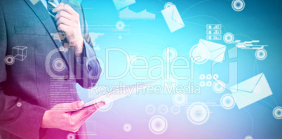 Composite image of businessman holding digital tablet