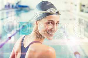 Composite image of pretty swimmer by the pool smiling at camera