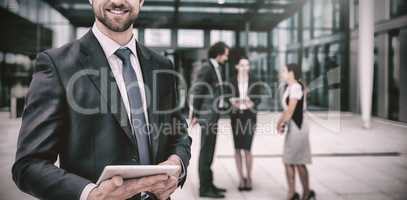 Happy businessman holding digital tablet