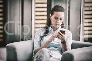 Businesswoman sitting and using mobile phone