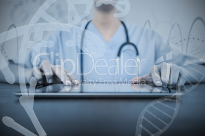 Composite image of mid-section of female doctor using digital tablet