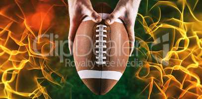Composite image of american football player holding up football
