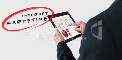 Composite image of businessman touching digital tablet