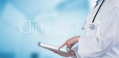 Composite image of midsection of female doctor using digital tablet