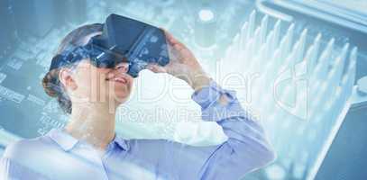 Composite image of low angle view of businesswoman using virtual reality headset