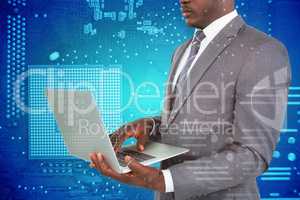 Composite image of midsection of businessman using laptop