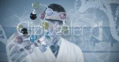Composite image of scientist holding molecule structure