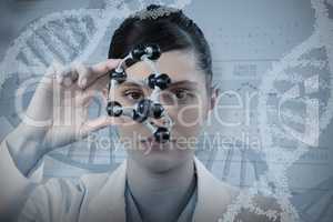 Composite image of female scientist looking through molecular model