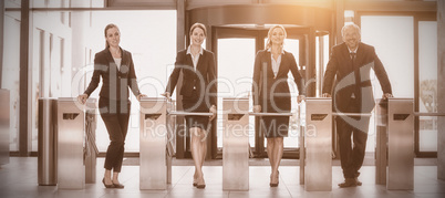 Businesspeople standing at turnstile gate