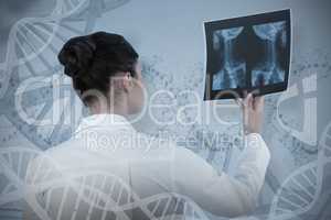 Composite image of female doctor checking x-ray report