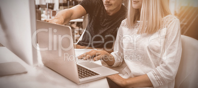 Graphic designers working over laptop at desk