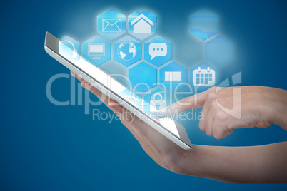 Composite image of hands using digital tablet against blue background