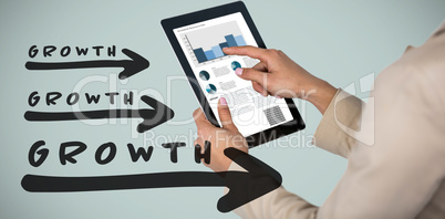 Composite image of businesswoman using digital tablet