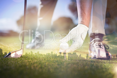Composite image of golfer placing golf ball on tee