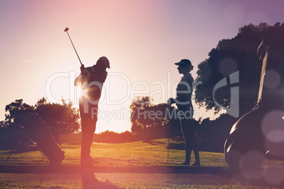 Composite image of golfing couple playing together