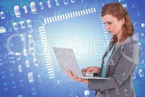 Composite image of businesswoman typing on laptop computer