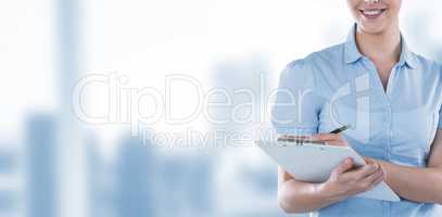 Composite image of beautiful businesswoman writing on clipboard