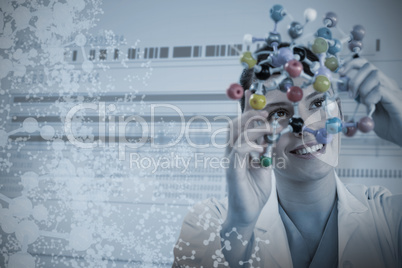 Composite image of happy female scientist holding molecular model