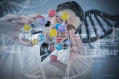 Composite image of scientist holding colorful molecule structure
