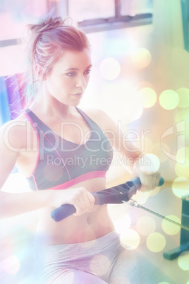 Composite image of woman pulling on row machine