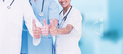 Composite image of portrait of smiling doctors with thumbs up