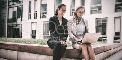 Businesswomen sitting and using laptop