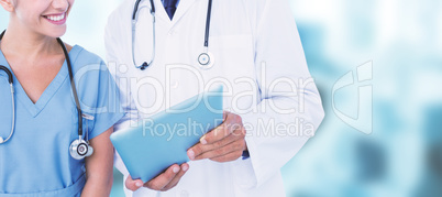 Composite image of smiling male doctor with nurse using digital tablet
