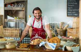 Portrait of male staff standing at counter in bake shop