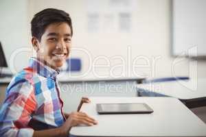 Schoolboy with digital tablet at desk