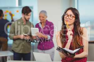 Thoughtful female executive holding organizer