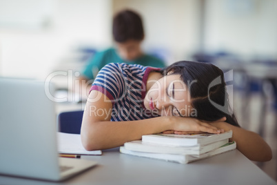 Tired schoolgirl sleeping in classroom