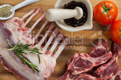 Rib rack, rib chops and ingredients on wooden board