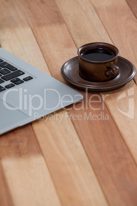 Cup of black coffee and laptop