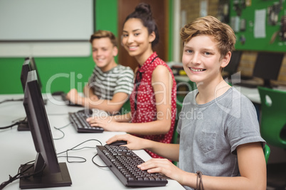 Smiling students studying in computer classroom