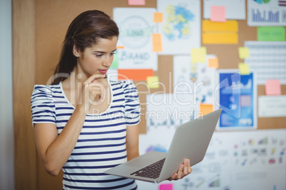 Female executive using laptop in office