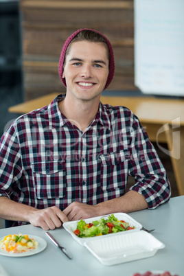 Smiling business executive having meal in office