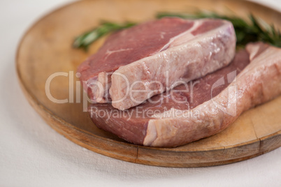 Sirloin chop and rosemary herb in wooden tray