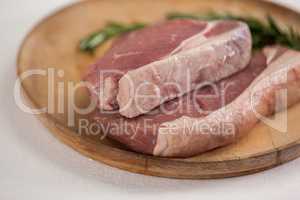 Sirloin chop and rosemary herb in wooden tray
