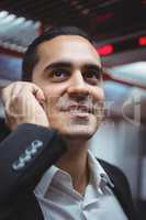 Executive talking on mobile phone in train