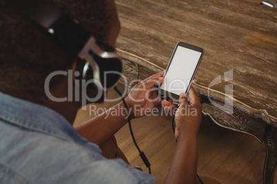 Man listening to music on mobile phone in living room